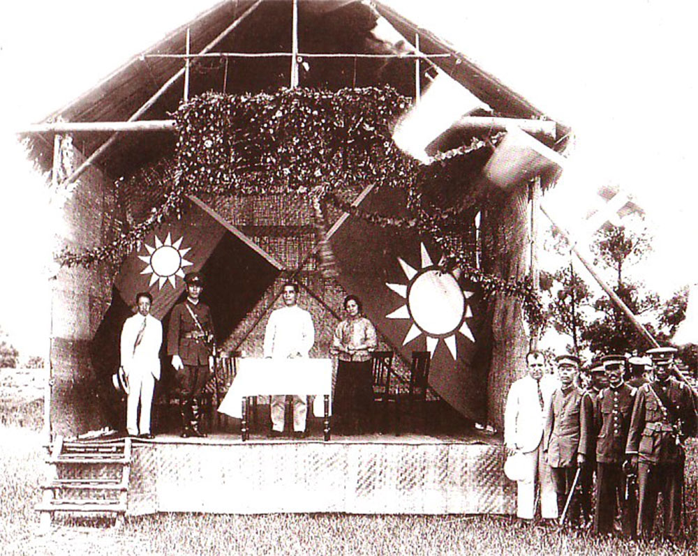 Sun Yat-sen [middle behind the table] and Chiang Kai-shek [on stage in uniform] at the founding of the Whampoa Military Academy in 1924