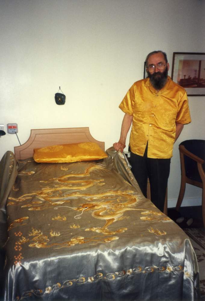 Reverend Jack Weir, formerly a missionary in Manchuria, at his home in Belfast, with the bed cover of Pu Yi, the last Emperor of China